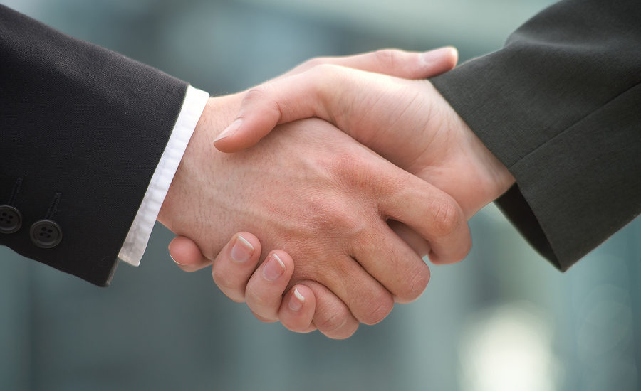 Close-up of a professional handshake between two individuals in business attire.