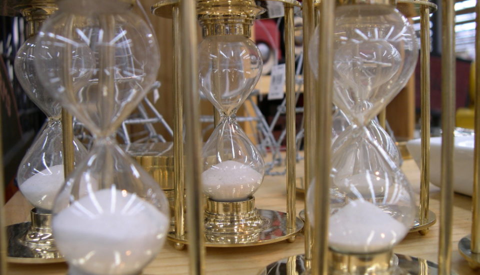 Close-up view of multiple golden hourglasses with white sand.