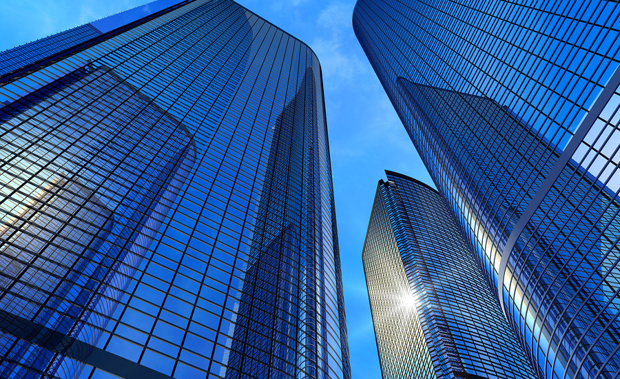 Modern glass skyscrapers reflecting the blue sky, symbolizing corporate success and innovation.
