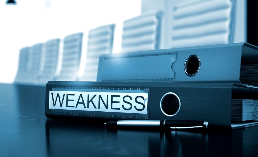 Black folder labeled "Weakness" on a conference table.