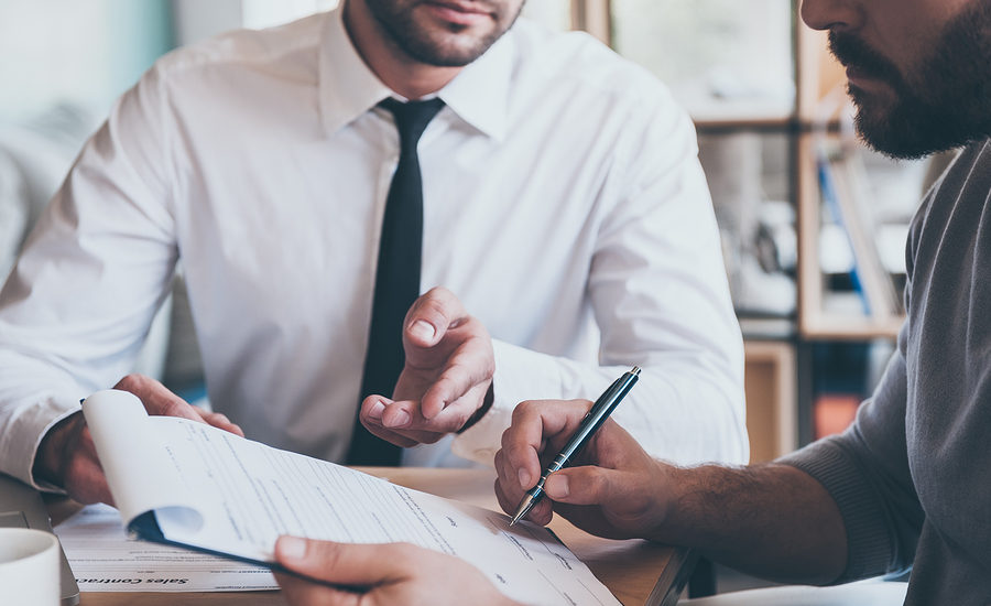 Business professionals reviewing and discussing documents at a desk.
