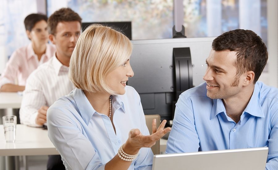 Business colleagues discussing ideas during a meeting in an office setting.