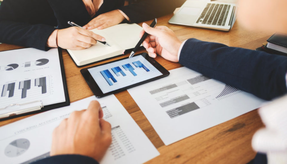 Business professionals analyzing financial data and charts during a meeting.