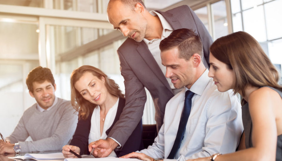 Business team collaborating in a meeting with a leader providing guidance.