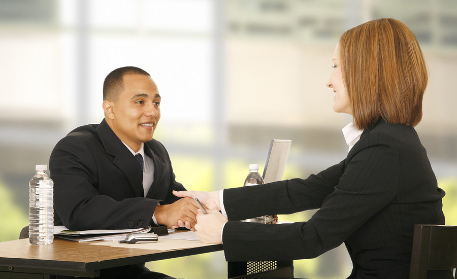 Two business professionals shaking hands during a meeting.