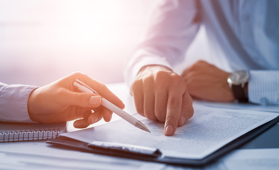 Close-up of two professionals reviewing and discussing a document.