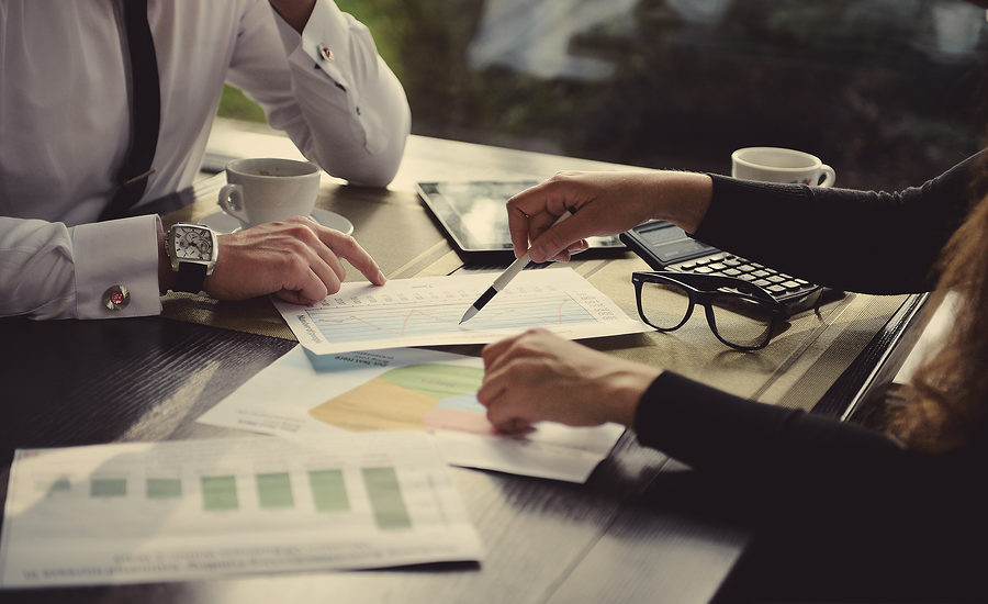Professionals reviewing financial graphs and data at a table.