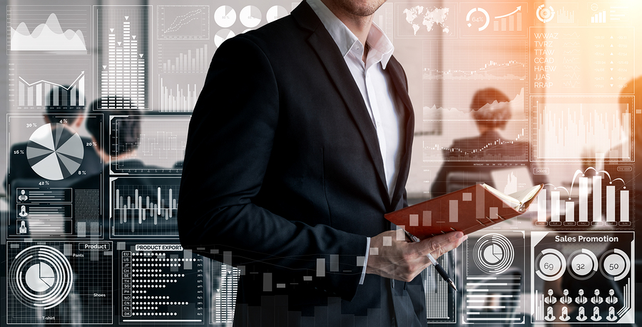 A business professional in a suit holding a notebook, with data analytics and charts in the background.