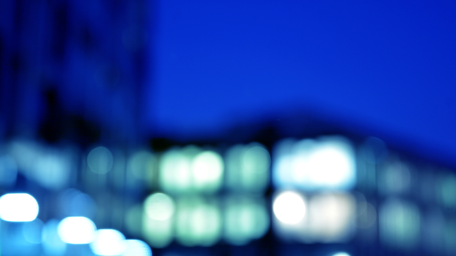 Abstract blurred lights of a building at night with a deep blue background.