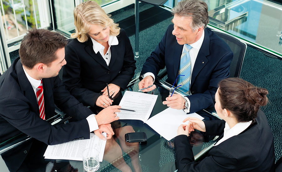 Professional business team discussing documents during a meeting at a modern office.