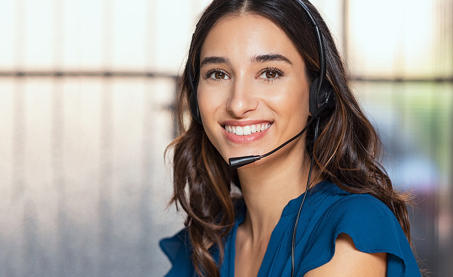 Smiling customer support representative wearing a headset.