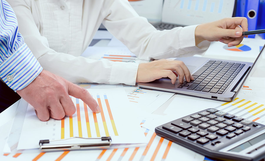 Business professionals reviewing financial charts and data on a desk.