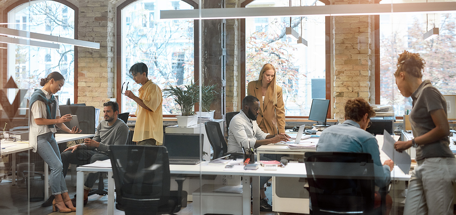 A diverse group of professionals working together in a modern open office space.