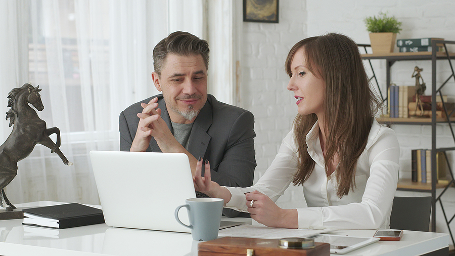 Business professionals collaborating on a project while discussing ideas in a modern office.