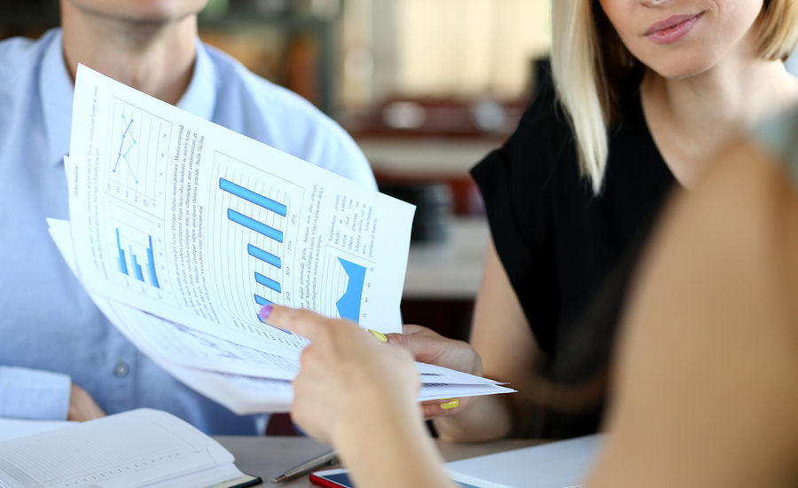 Close-up of business professionals reviewing charts and graphs during a meeting.