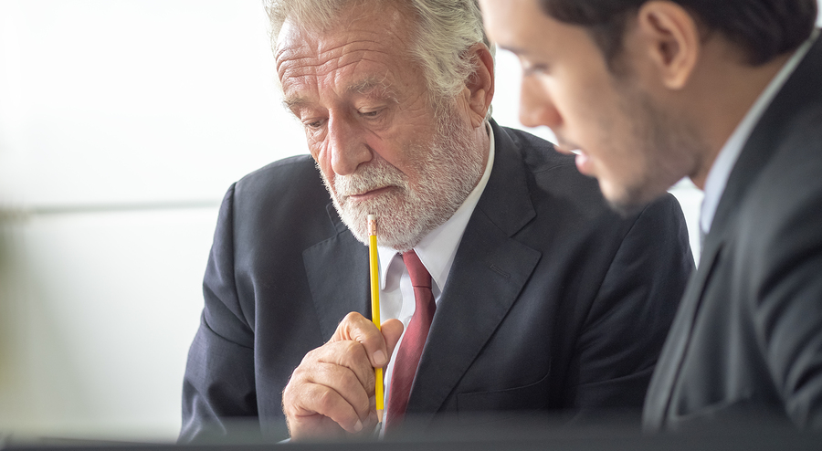 Senior business executive consulting with a colleague.