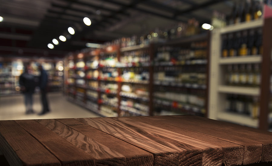 Wooden countertop with blurred supermarket shelves in the background.