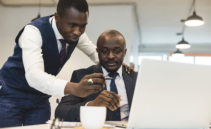 Two business professionals collaborating on a project using a laptop, emphasizing teamwork and strategic planning.