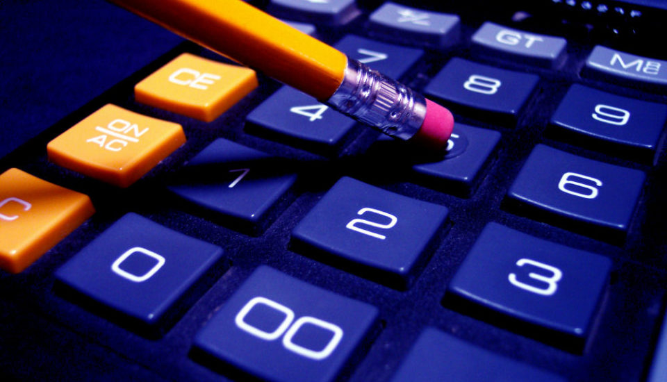 Pencil tapping on calculator keys.