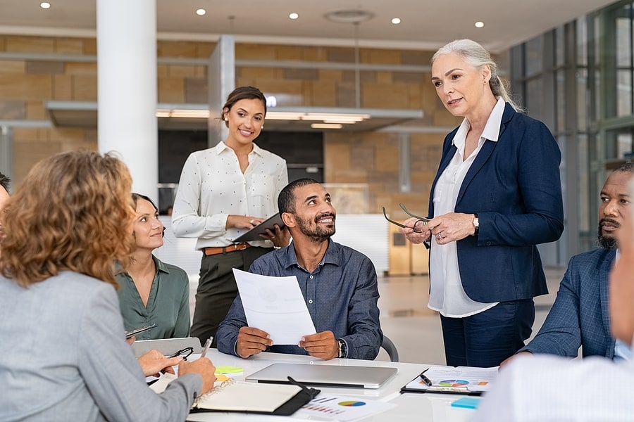 Group of business professionals in a meeting discussing documents.