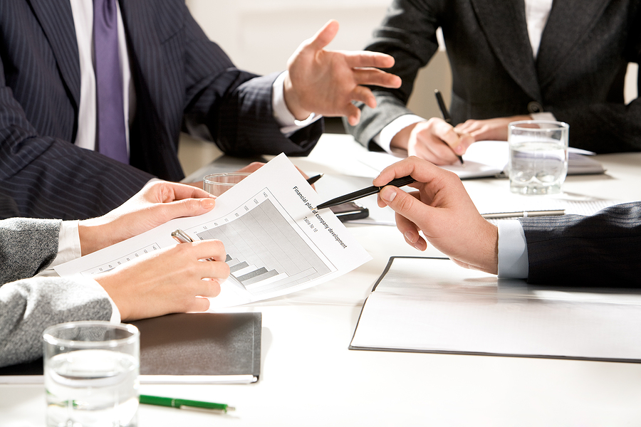 Business professionals reviewing financial growth graphs during a meeting.