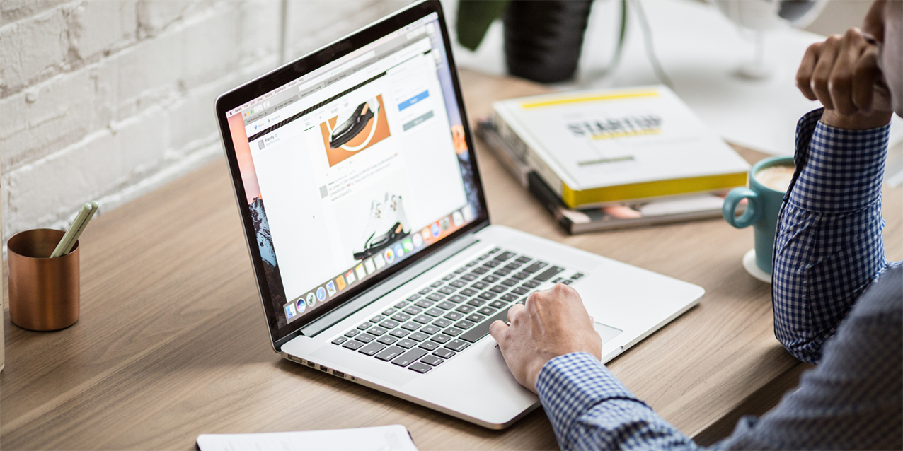 Entrepreneur researching business deal killers on a laptop at desk