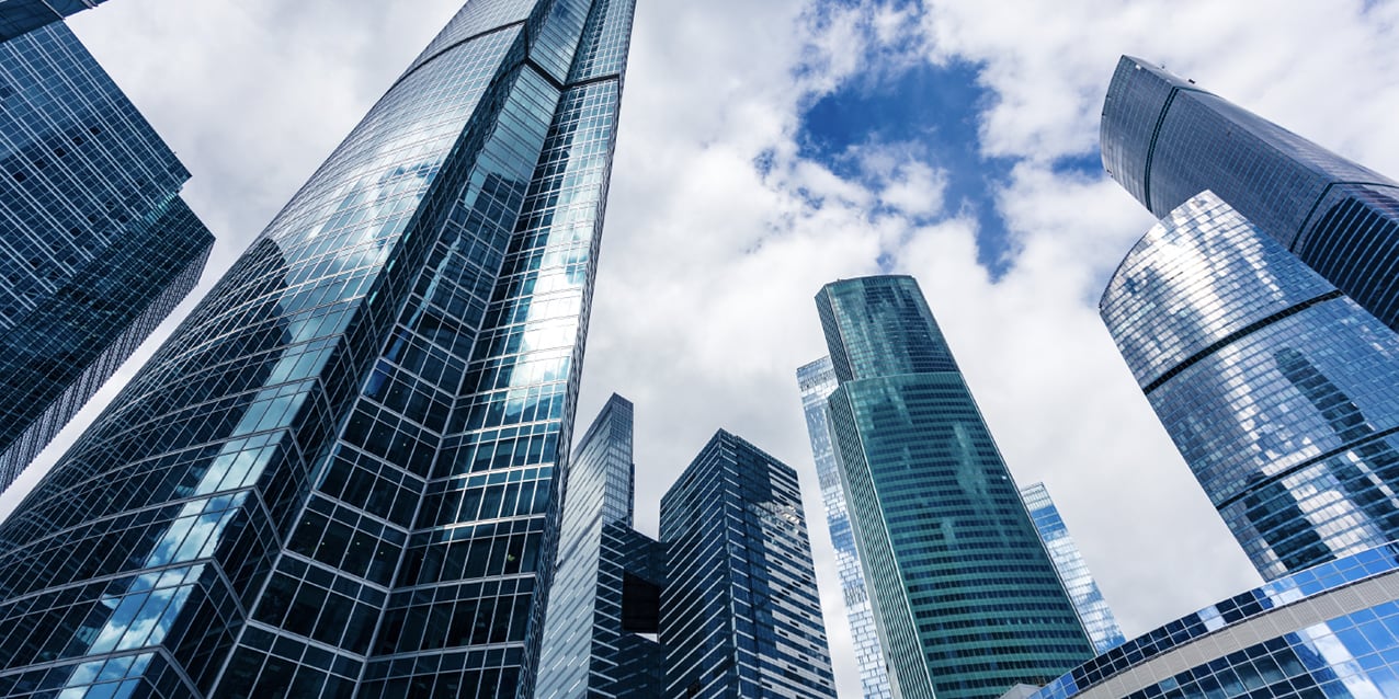 glass skyscrapers reaching into a bright sky in a modern business district